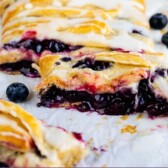 Blueberry danish with slices cut off and recipe title on the bottom of photo