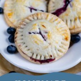 Three blueberry hand pies on a plate with recipe title on bottom of photo