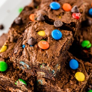 Overhead shot of M&M brownies cut in squares and stacked on top of eachother