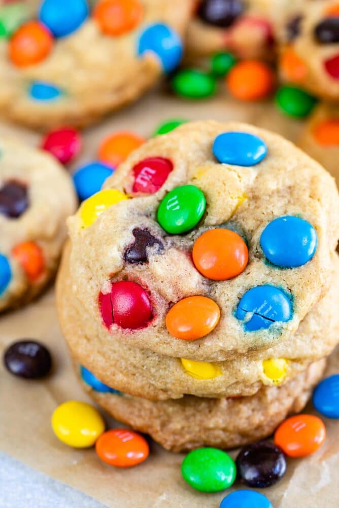 Stack of chocolate chip M&M cookies on parchment paper