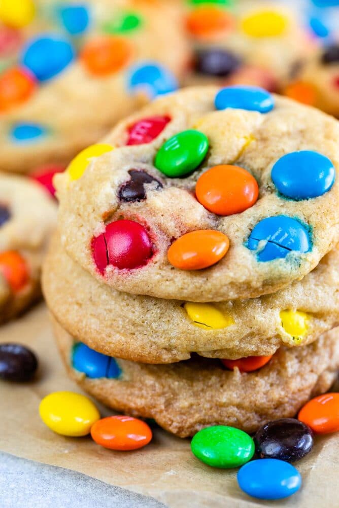 Stack of chocolate chip M&M cookies on parchment paper
