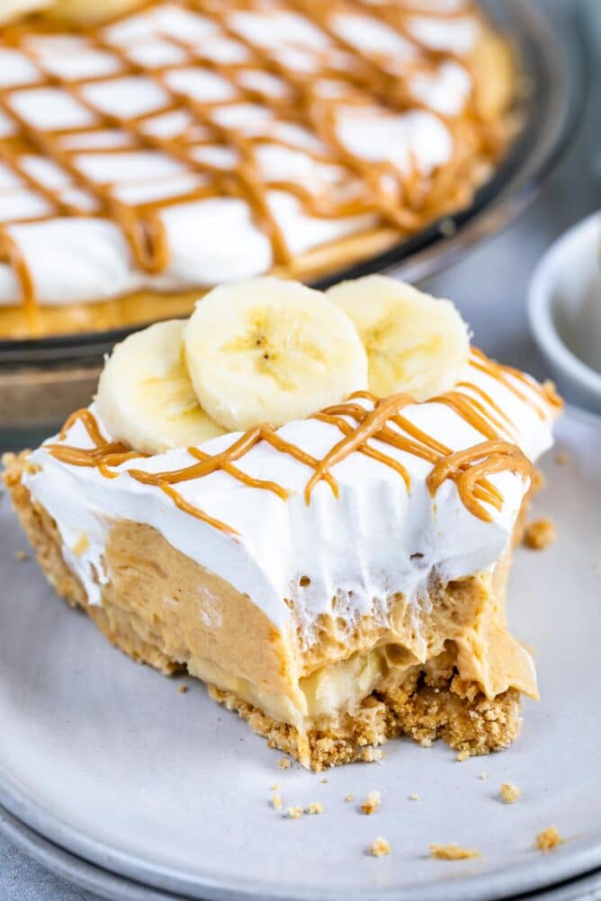One slice of no bake peanut butter banana cream pie with one bite missing