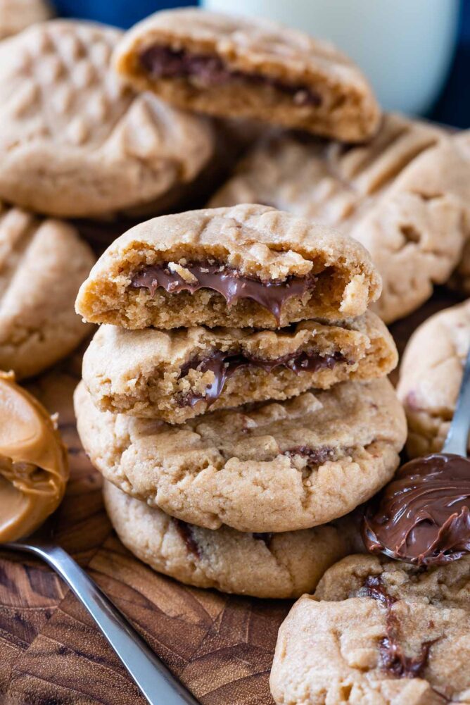 stack of peanut butter cookies with cut in half cookies on top stack with Nutella inside