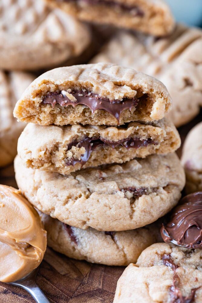 stack of peanut butter cookies with cut in half cookies on top stack with Nutella inside