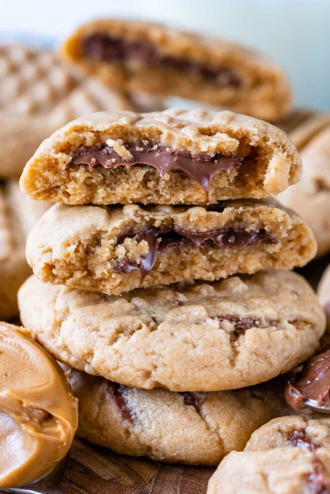 stack of peanut butter cookies with cut in half cookies on top stack with Nutella inside