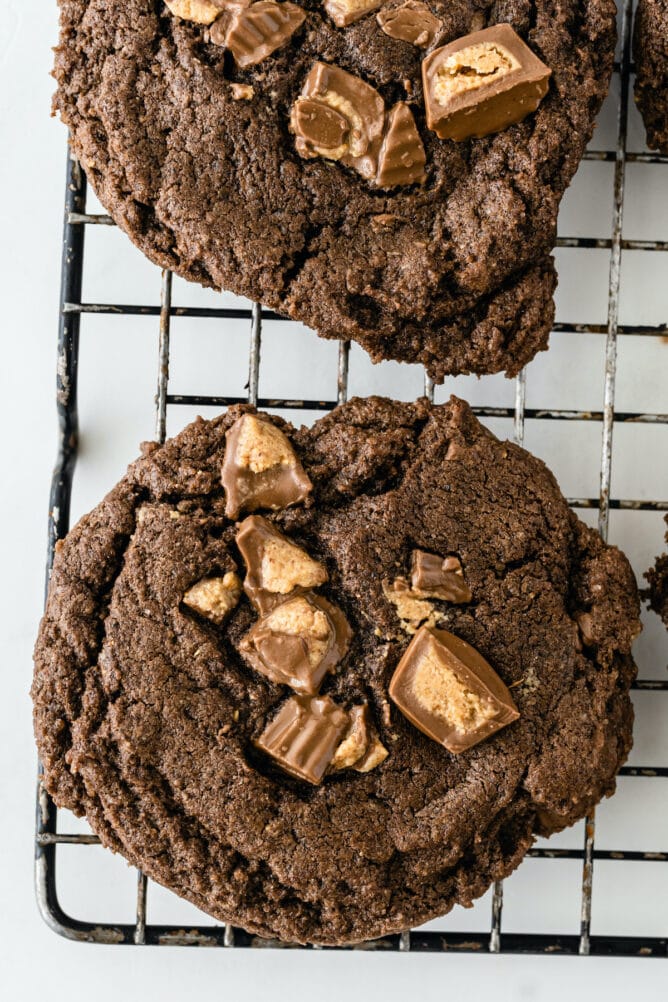 Overhead shot of soft chocolate peanut butter cup cookies on a metal cooling rack