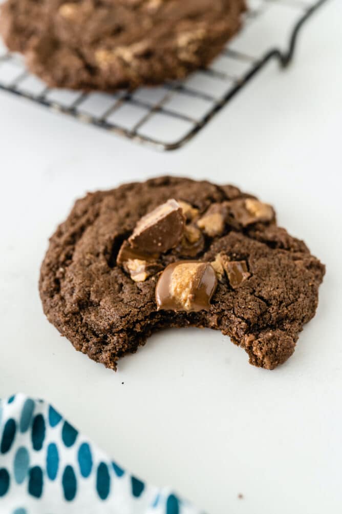 One soft chocolate peanut butter cup cookie with a bite taken out of it