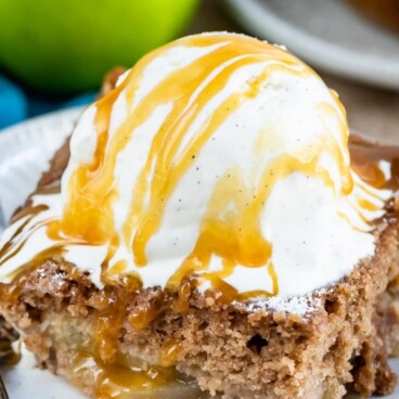 Slice of apple pie cake topped with ice cream and recipe title on top of image