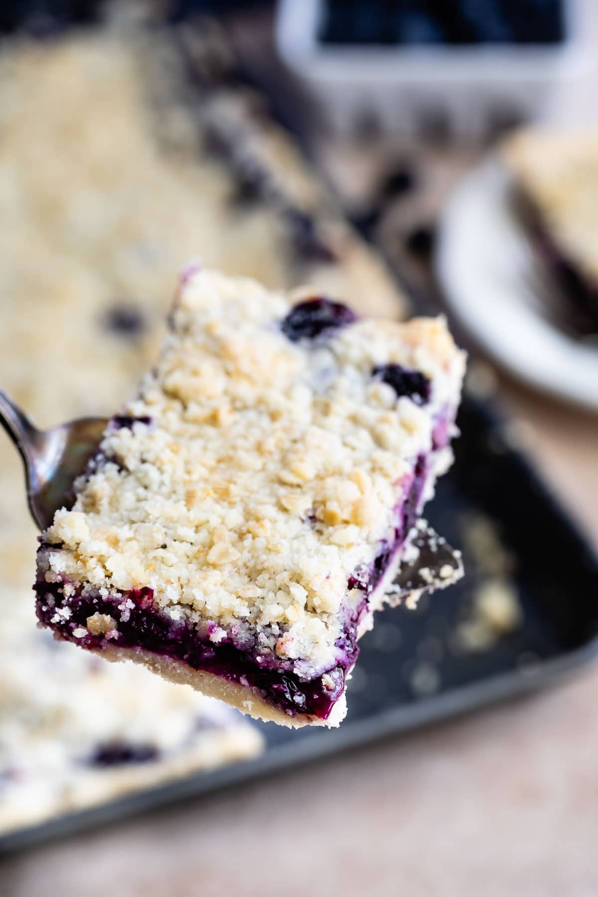 Close up shot of one piece of blueberry slab pie on a serving spoon