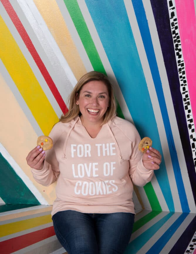 woman in sweatshirt holding cookies