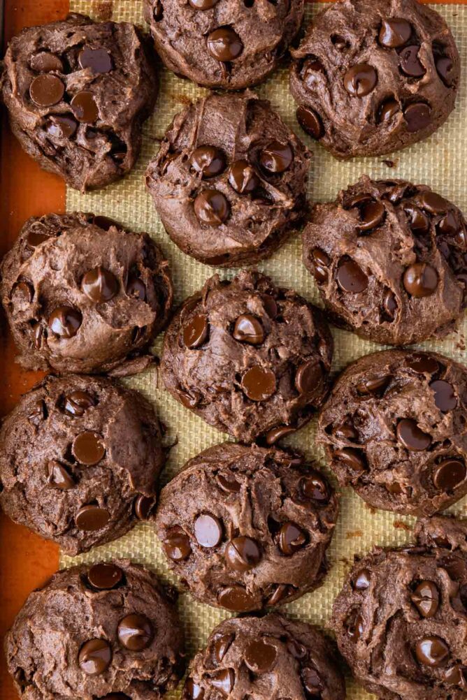Overhead view of chocolate cake mix cookies on a silicon baking sheet