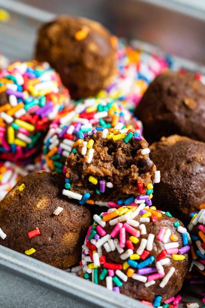 Close up shot of double chocolate chip edible cookie dough balls with some rolled in rainbow sprinkles