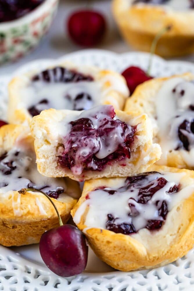 cherry pie danish with drizzle on a stack of bites with one cut open