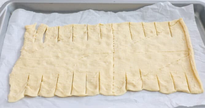 crescent roll dough flattened on cookie sheet