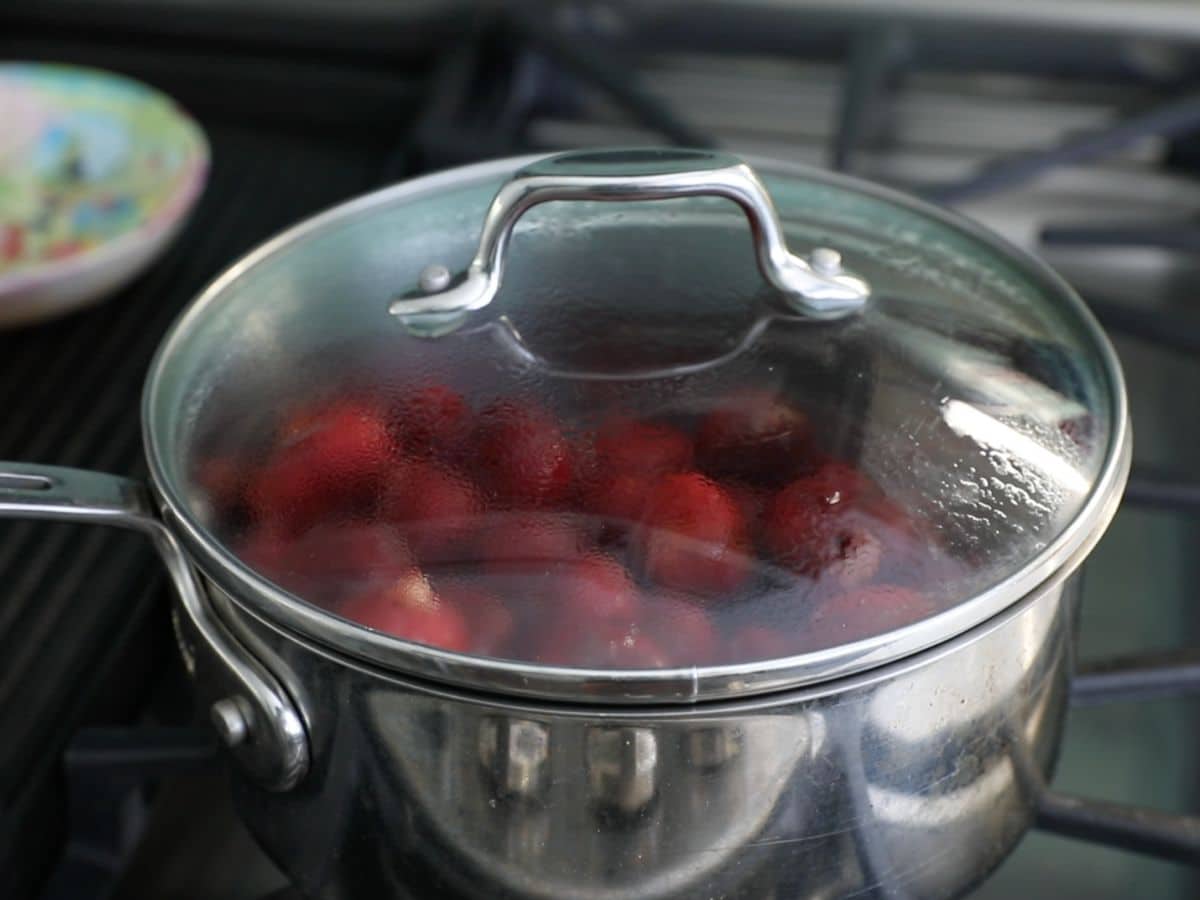 cherries in saucepan with clear lid.