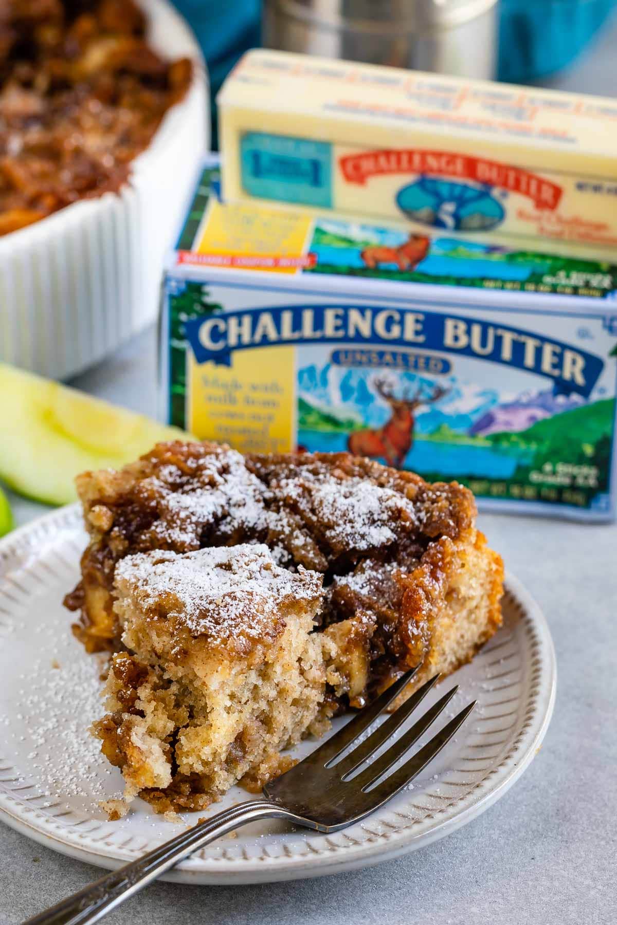 Apple Coffee Cake slice on white plate with butter box behind