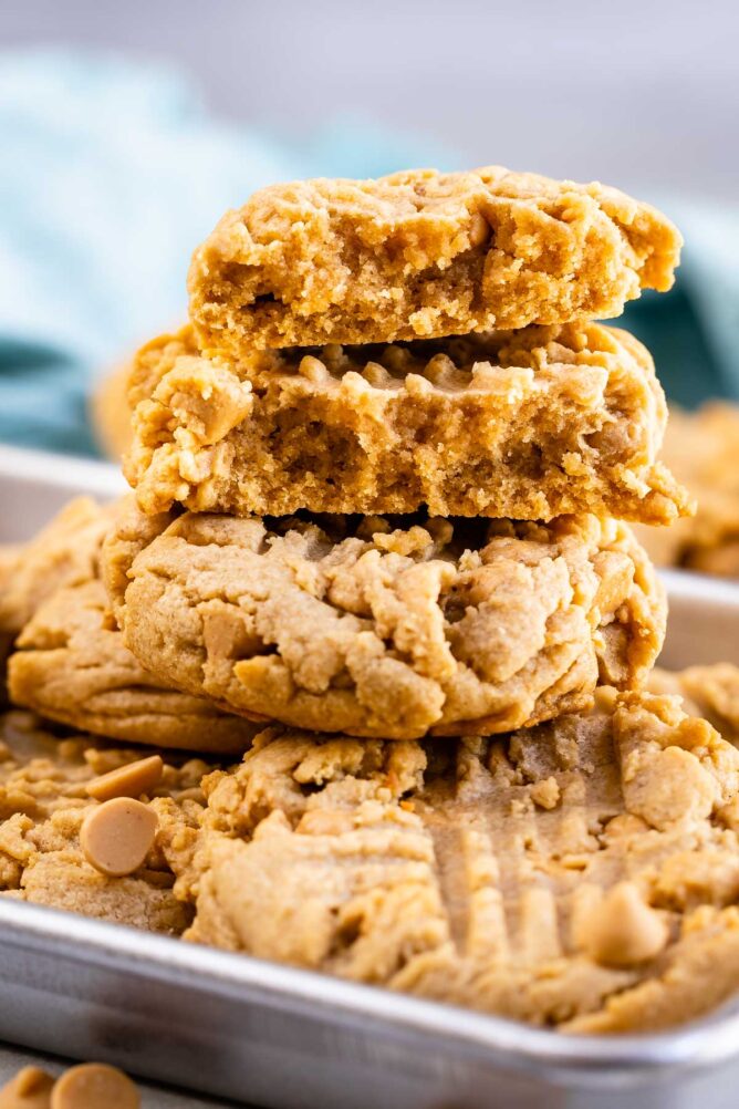 Stack of XL bakery style peanut butter cookies with top cookie split in half to show inside