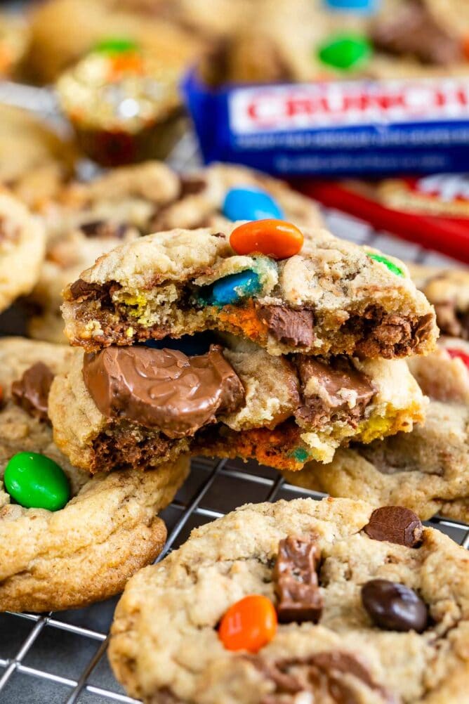 Close up shot of candy bar cookies on a metal cooling rack with cookie split in half to show candy inside