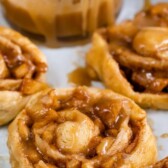 Close up shot of easy caramel apple cinnamon rolls with caramel topping and recipe title on top of image