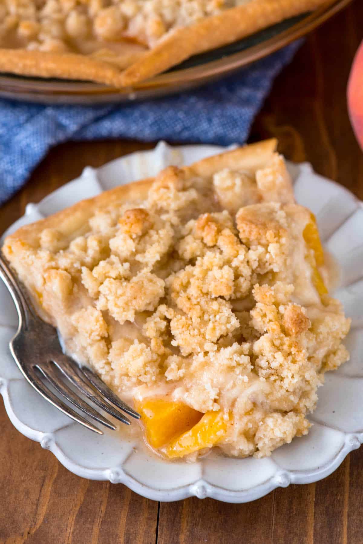 peach crumble pie on white plate with fork