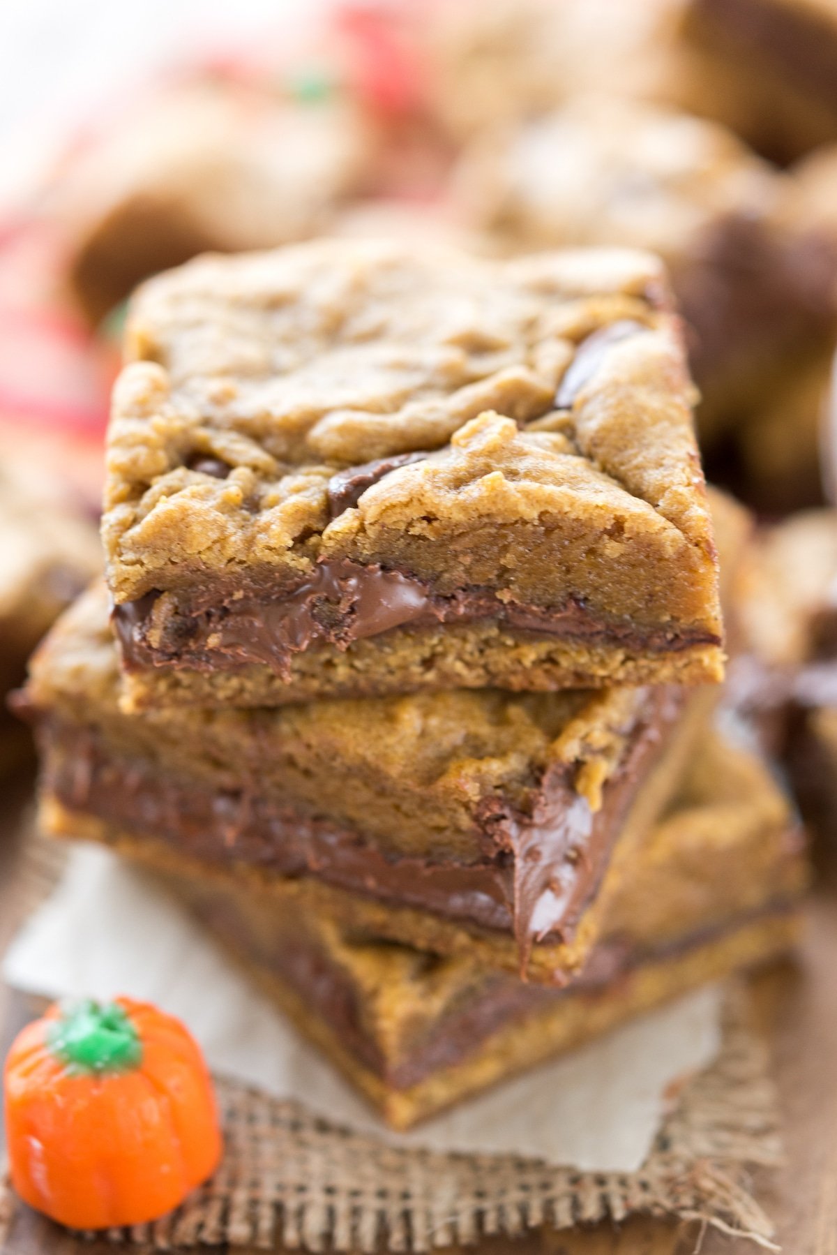 Three pumpkin nutella cookie bars with a pumpkin candy next to it