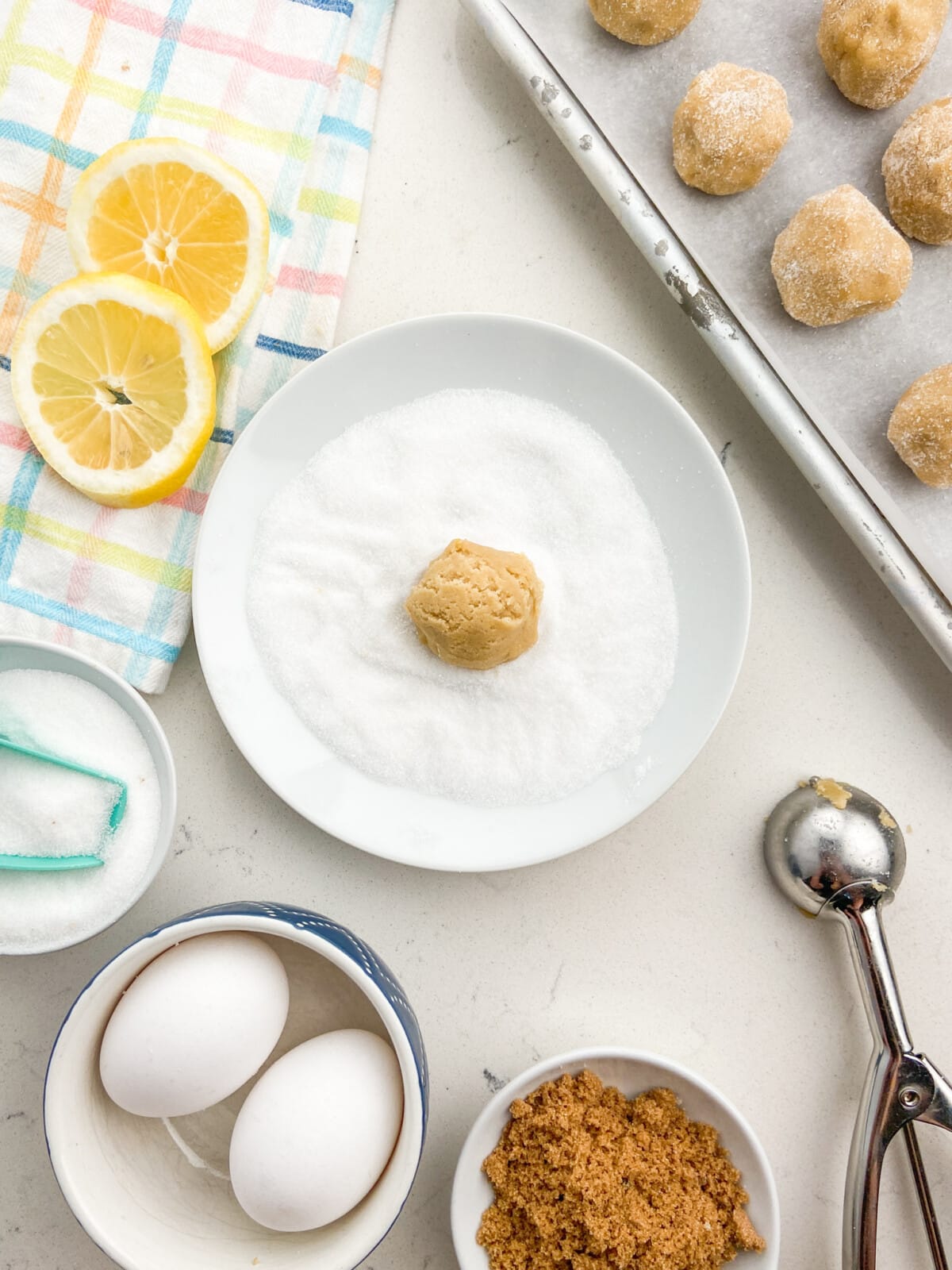cookie ball in bowl of granulated sugar.