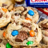 Close up shot of candy bar cookies on a metal cooling rack with recipe title on top of image