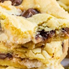 Stack of Caramel Apple Gooey Bars with rolo candies around them and recipe title on top of image