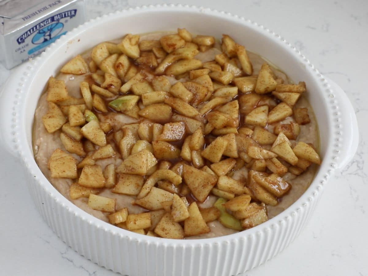 batter in pan with apples on top.