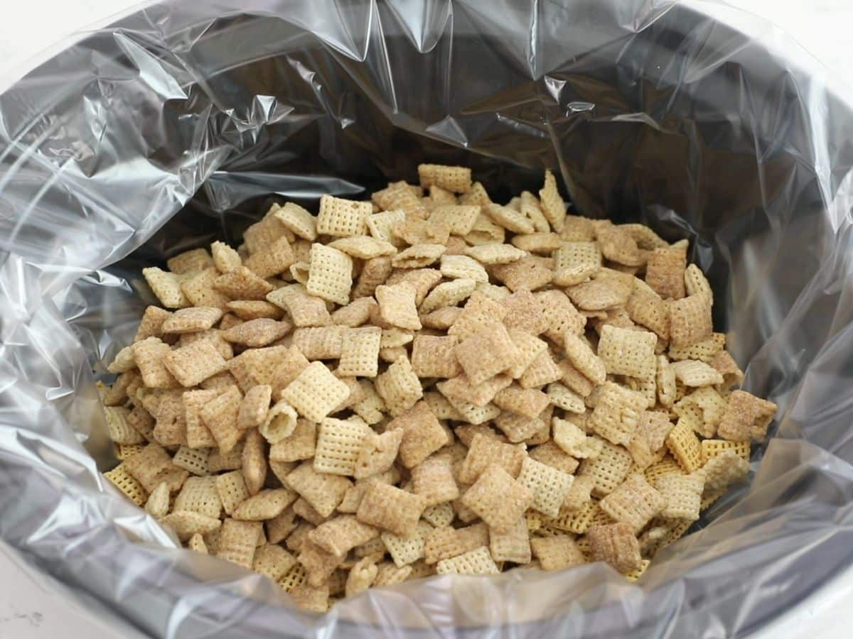 Chex mix in black slow cooker with liner