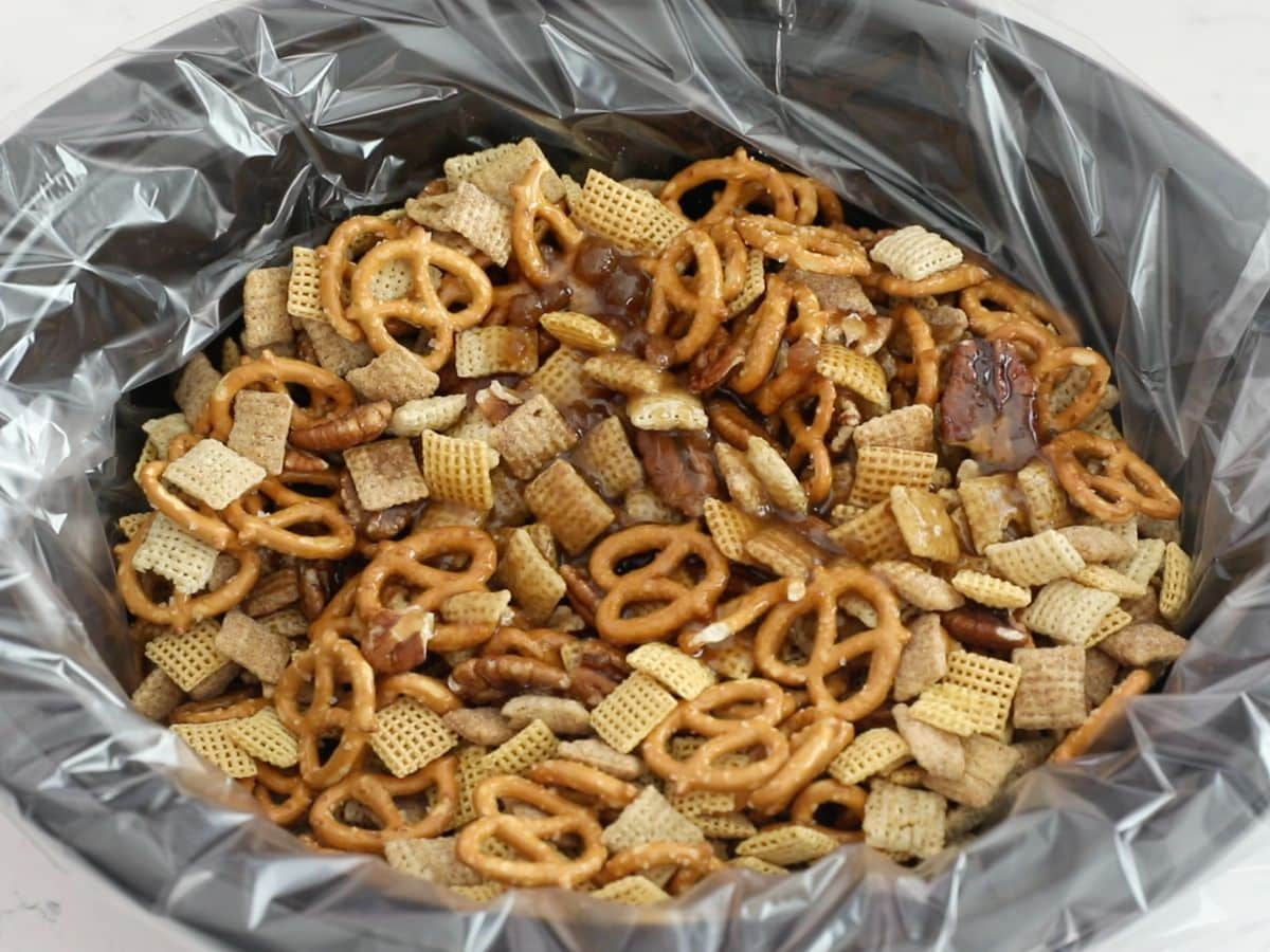 Chex mix in black slow cooker with liner