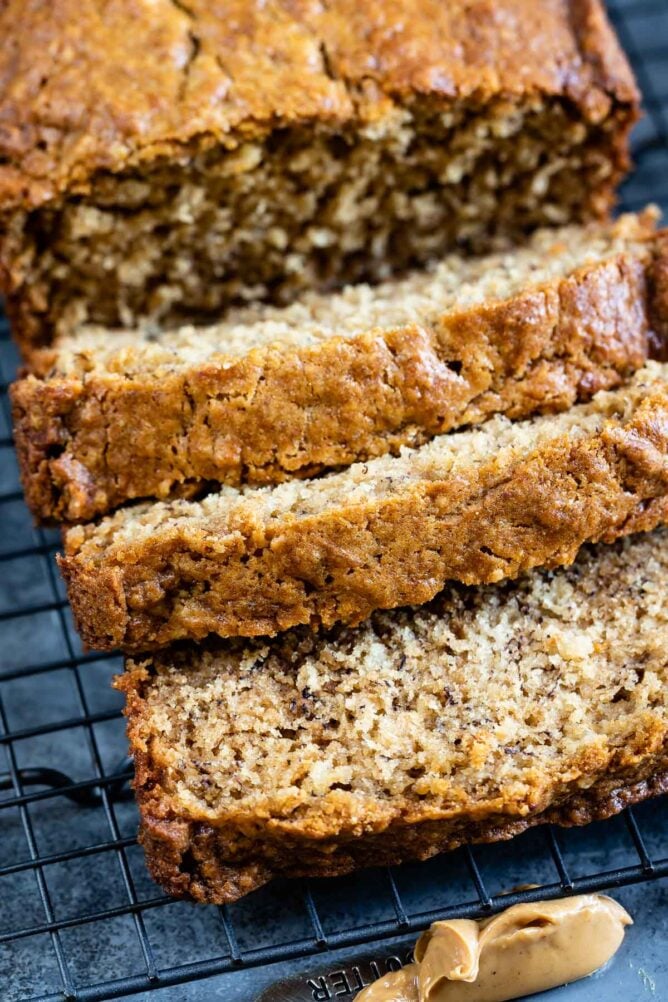 Loaf of peanut butter banana bread with three slices falling off the loaf