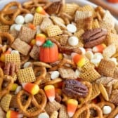 Large bowl of pumpkin spice chex mix with recipe title on top of image