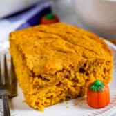 Slice of pumpkin snake cake on a plate next to pumpkin candies