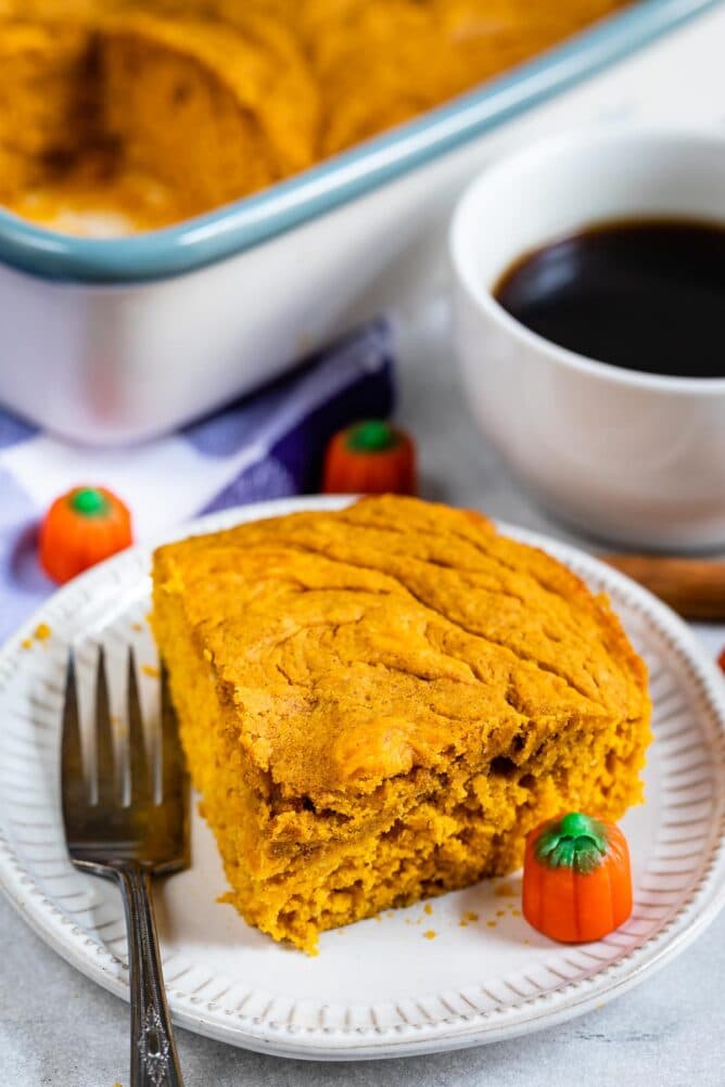 Overhead view of corner slice of pumpkin snack cake on a plate with a fork