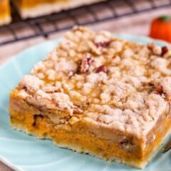 Pumpkin pie bar cut into a square on a light blue plate