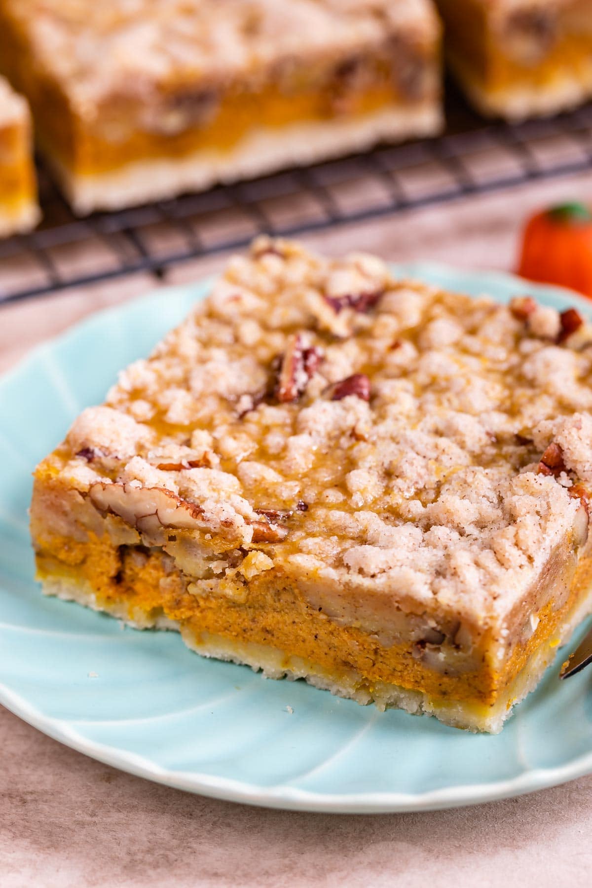 Pumpkin pie bar cut into a square on a light blue plate