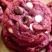 Stack of red velvet cookies with more cookies around it and recipe title on top of image