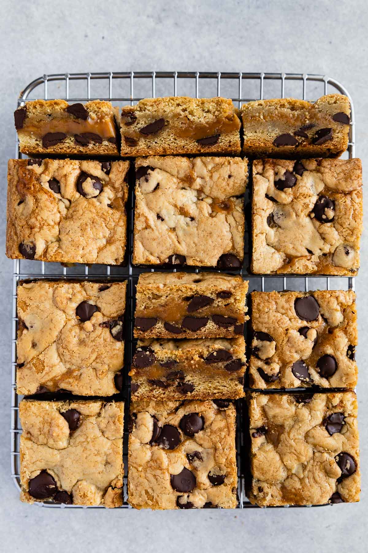 Overhead shot of caramel chocolate chip cookie bars cut into squares on wire cooling rack