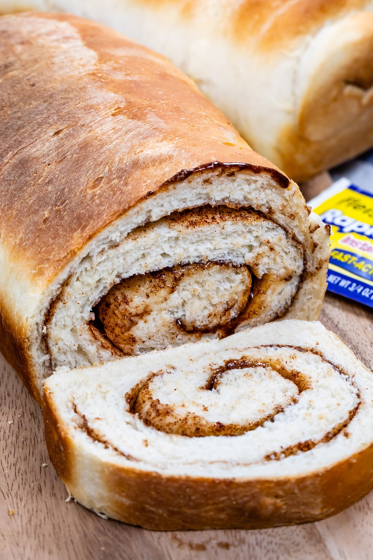 loaf of bread with slice showing cinnamon swirl.