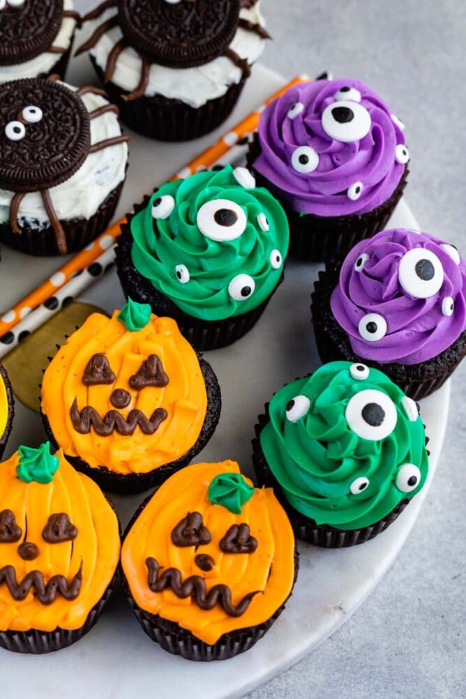 Overhead shot of halloween cupcakes decorated as pumpkins, spiders and monster eyes