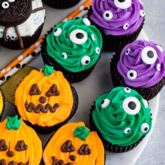 Overhead shot of halloween cupcakes decorated as pumpkins, spiders and monster eyes