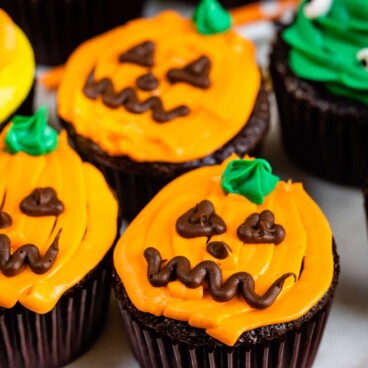 Three cupcakes decorated as pumpkins