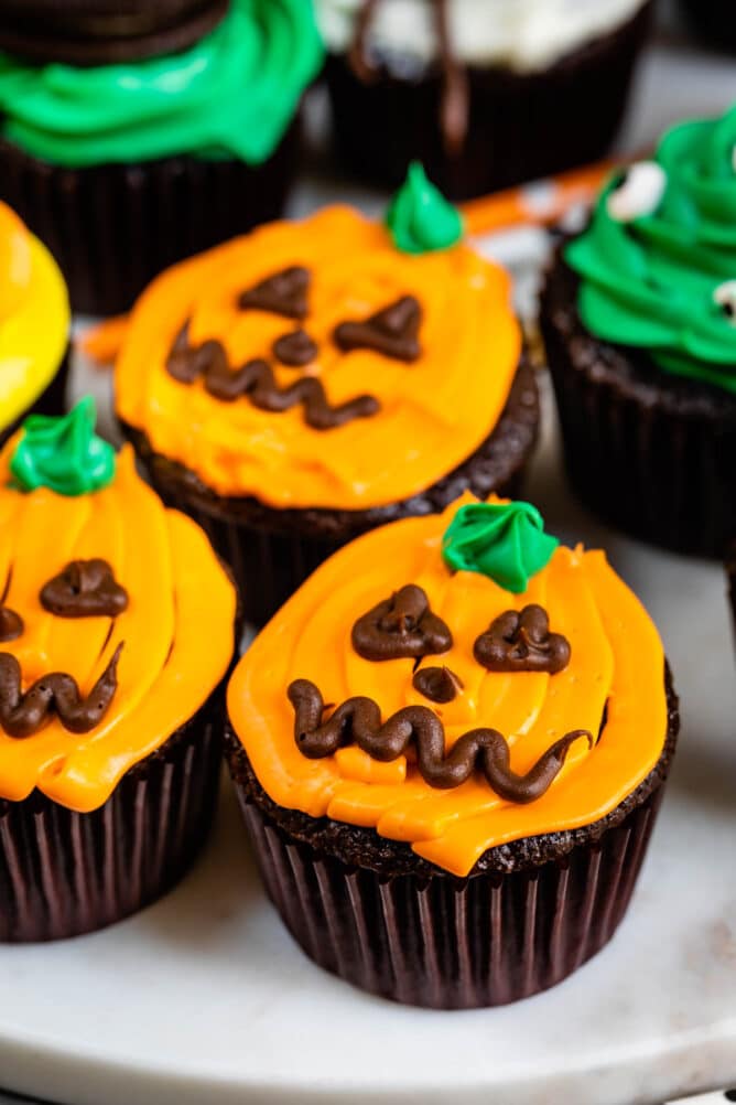 Three cupcakes decorated as pumpkins