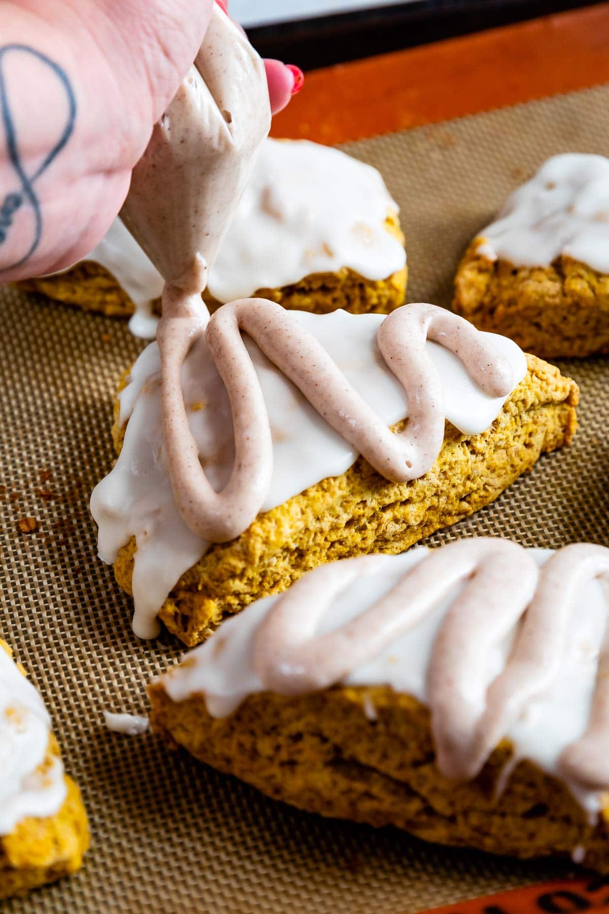 Close up shot of pumpkin scones being iced