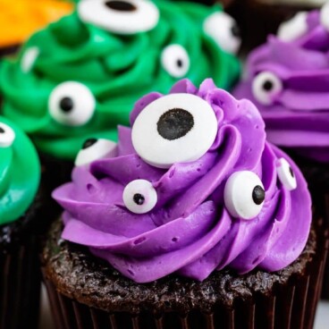cupcake with purple frosting and candy eyes