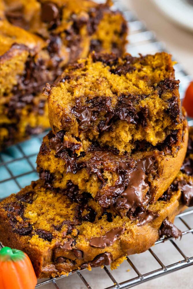 Stack of pumpkin chocolate chip bread slices on top of metal cooling rack