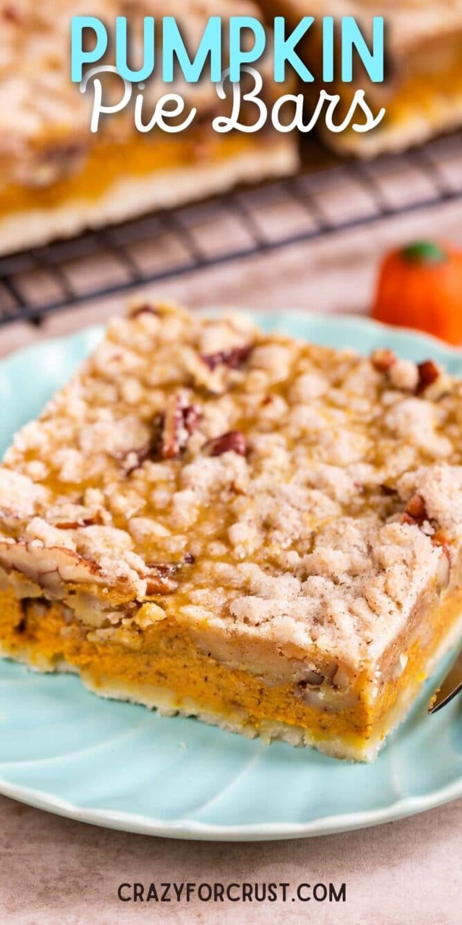 Pumpkin pie bar cut into a square on a light blue plate with recipe title on top of photo