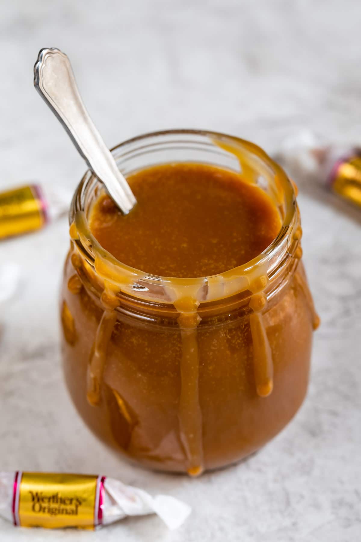 Three-ingredient caramel sauce in a jar with spoon inside