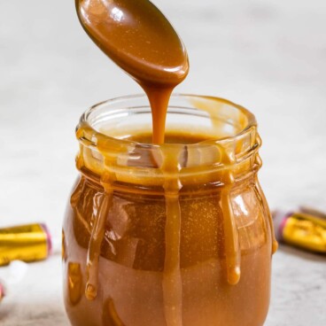 Spoonful of three-ingredient caramel sauce being poured back into the small jar